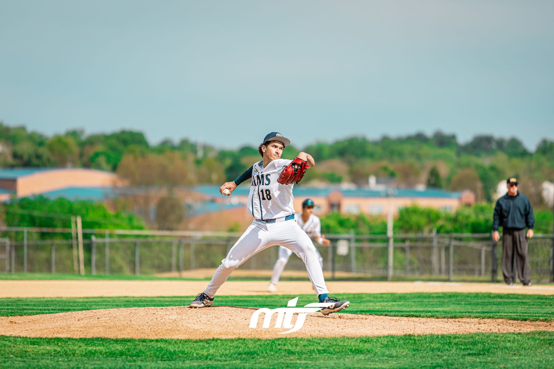 High school baseball pitcher mid-delivery on the mound