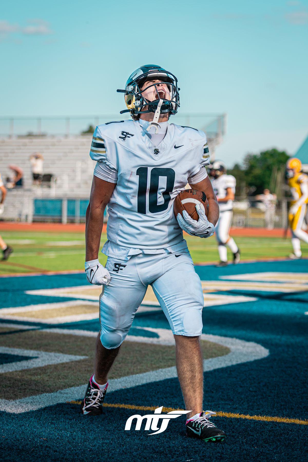 Football receiver celebrating a touchdown in the end zone