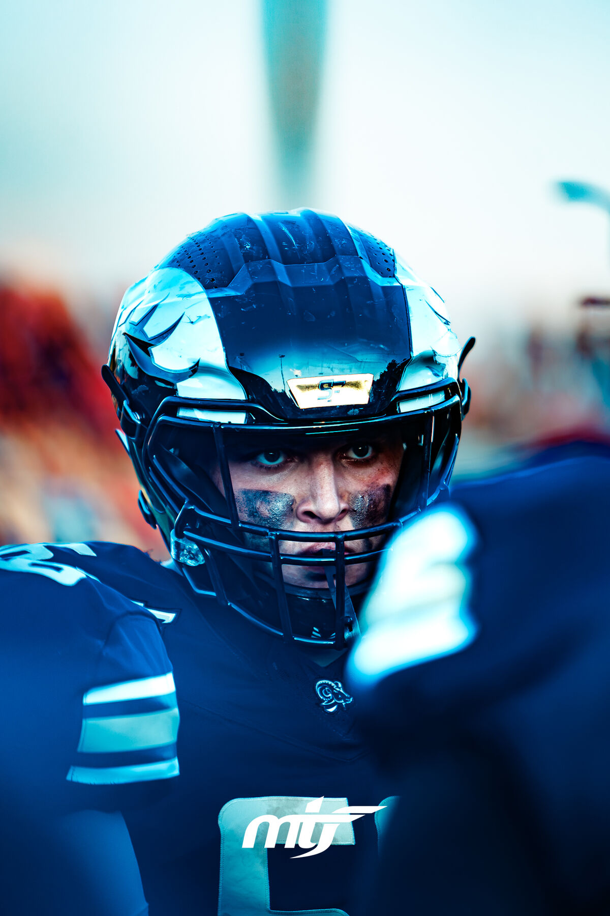 Close-up of a football player's intense expression through his facemask