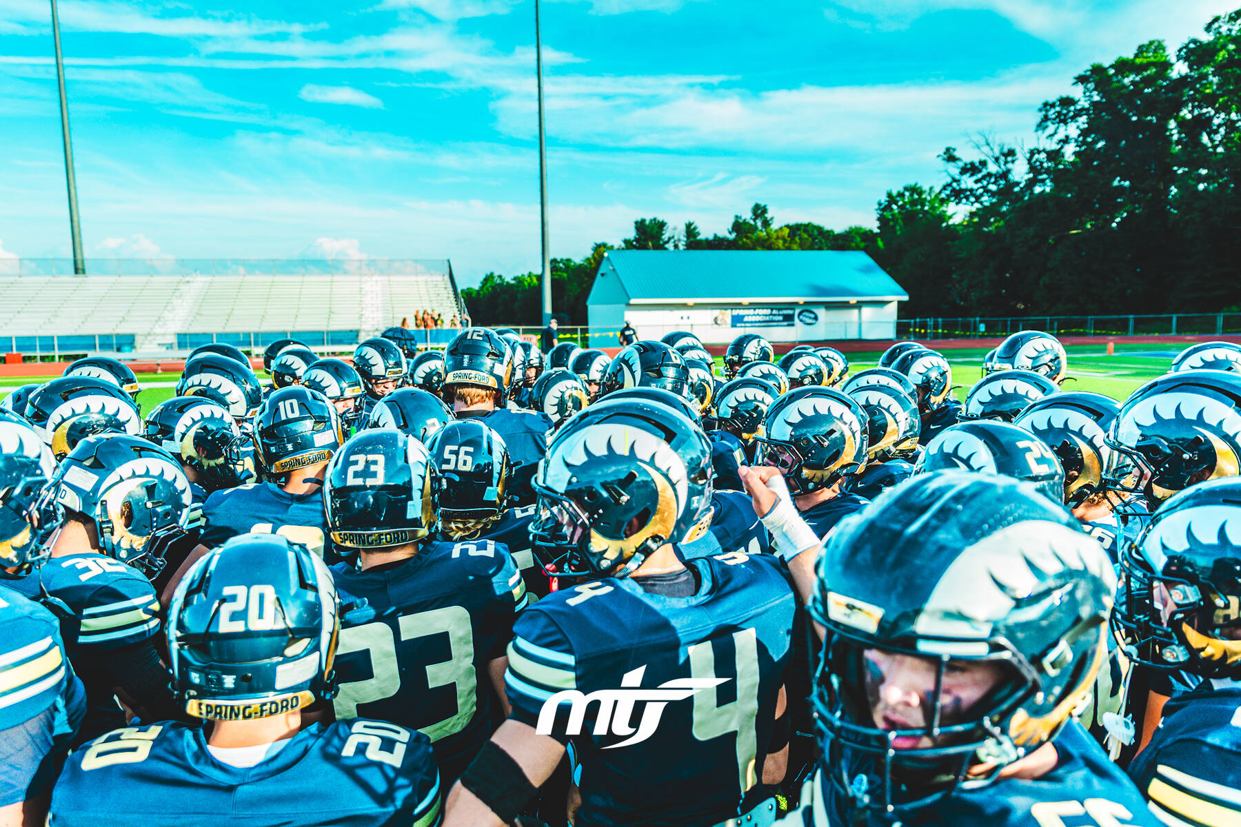 Spring-Ford football team huddled together on the sideline before a game